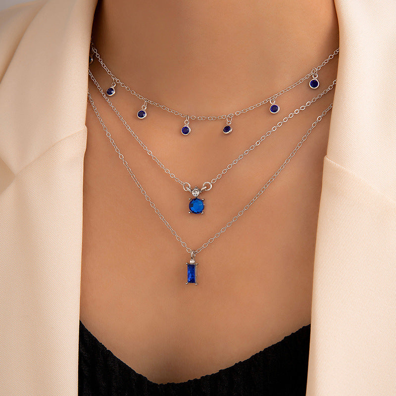 Multilayer pearl necklace with blue disc charms and silver chain, bar pendant drop