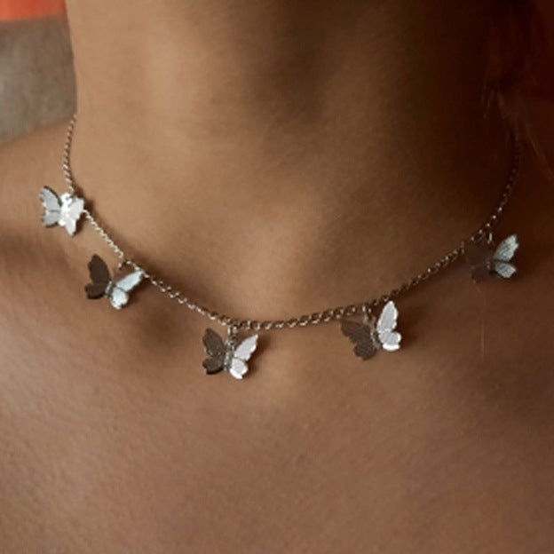 Silver butterfly pendant necklace with five butterfly charms along the chain