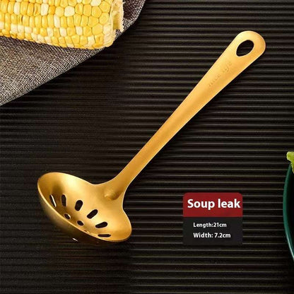 Gold soup ladle on a dark textured surface with corn on the cob.