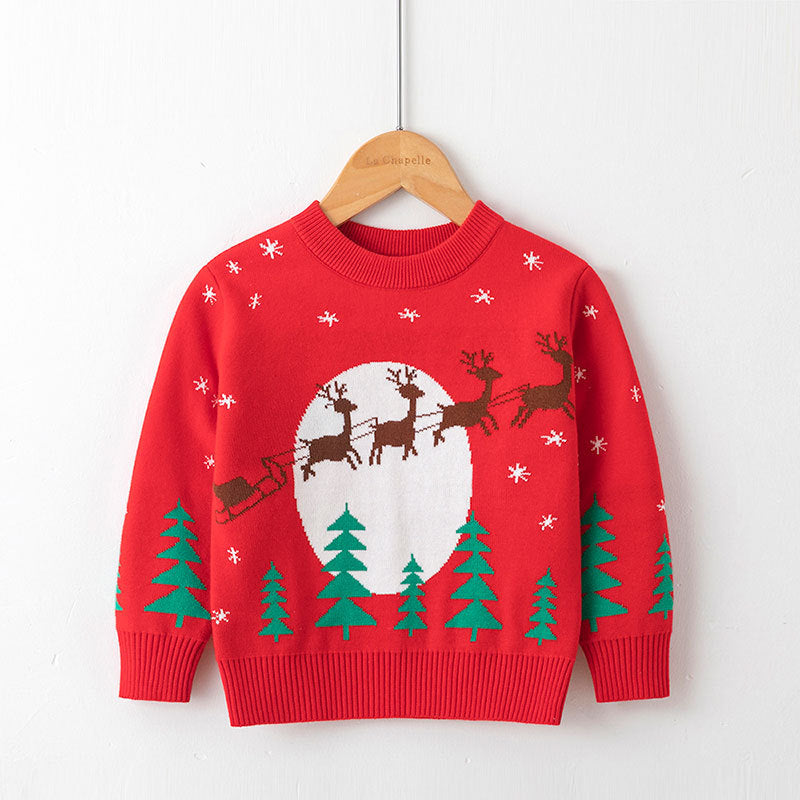 Kids red Christmas sweater with reindeer sleigh, green pine trees, and snowflake details