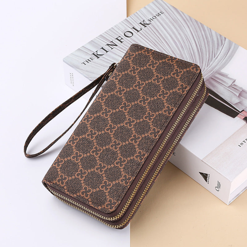 Brown patterned wallet clutch with wrist strap and zip closure