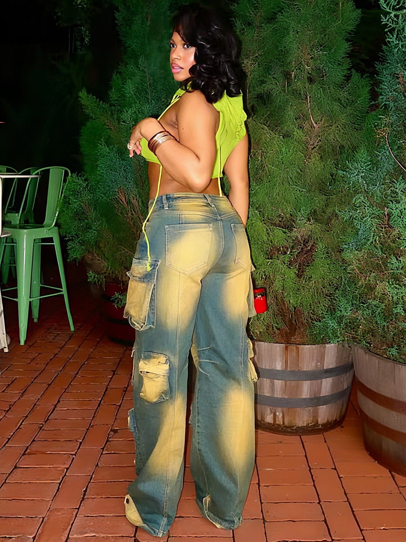 Loose green workwear jeans with wide legs, cargo-style flap pockets, and distressed panels