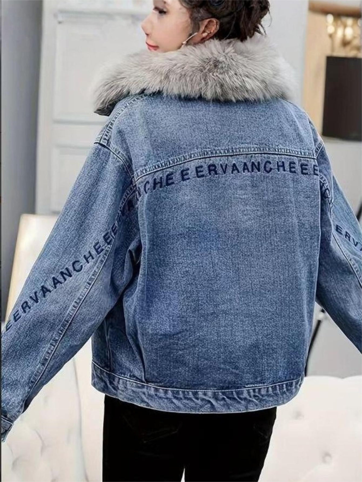Back view of light blue denim jacket with faux fur collar and branded sleeve stripe