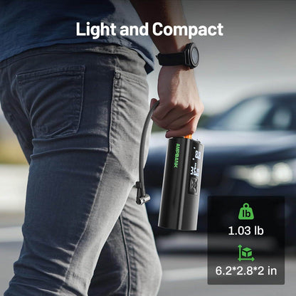 Black tire inflator with orange nozzle and digital screen held in hand