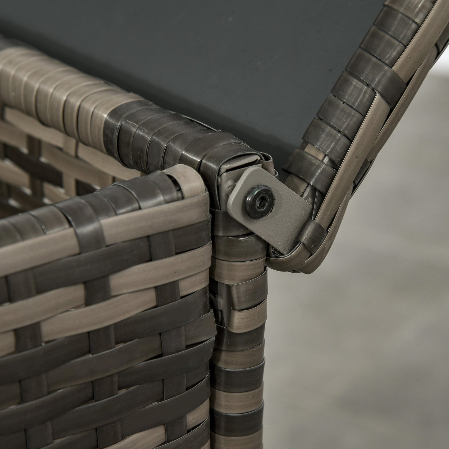 Resin wicker chair corner joint with gray cushion strap detail