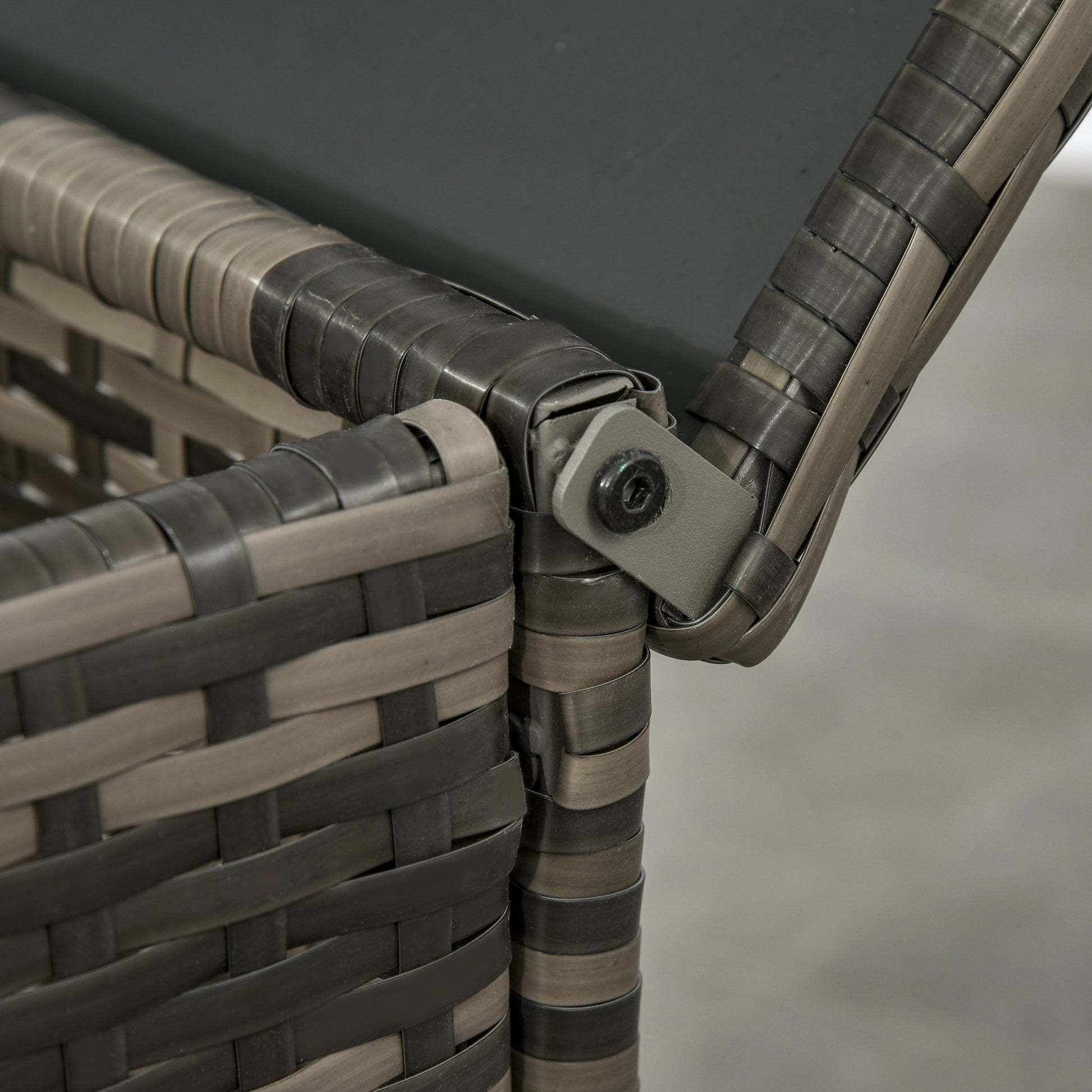 Resin wicker chair corner joint with gray cushion strap detail