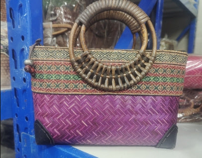 Woven bamboo handbag with brown handle, multicolor patterned top, purple woven body