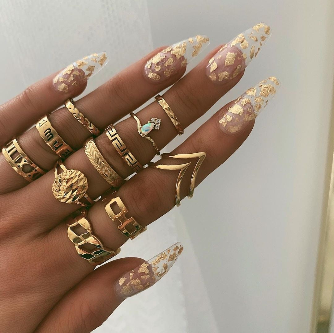 Gold-tone ring set with geometric bands and teal-blue heart stone