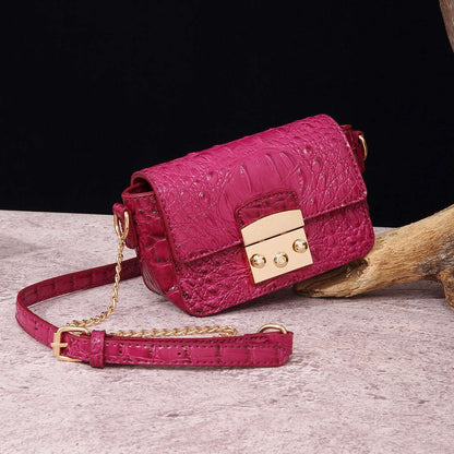 Fuchsia one-shoulder crossbody bag with textured finish and gold-tone clasp, chain strap.