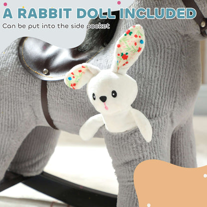 Close-up of gray plush rocking horse head with black reins and attached white rabbit doll