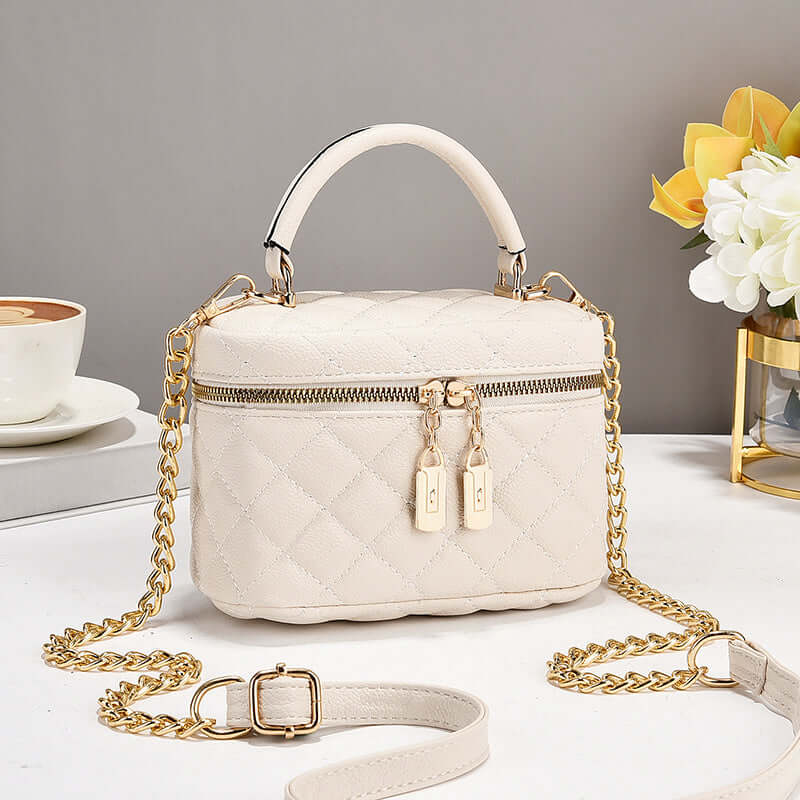 White quilted fashion tote with shoulder handles, gold chain strap, double zip pulls
