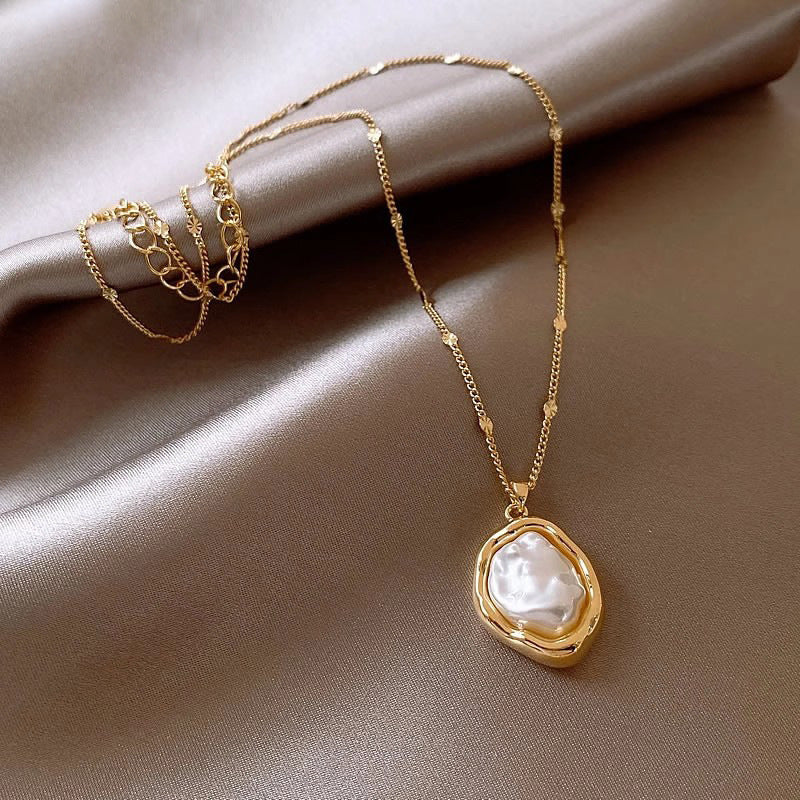 Gold-tone pearl pendant necklace with oval clasp-style centerpiece