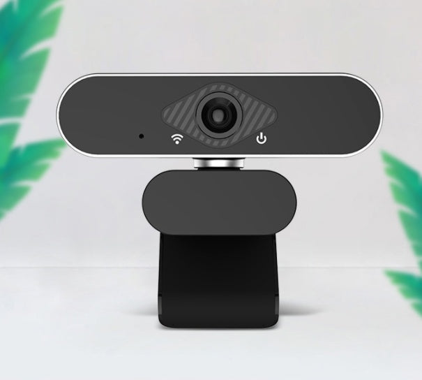 Black webcam on a white background with green leaves