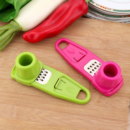 Light green manual garlic masher with grating plate beside another color masher