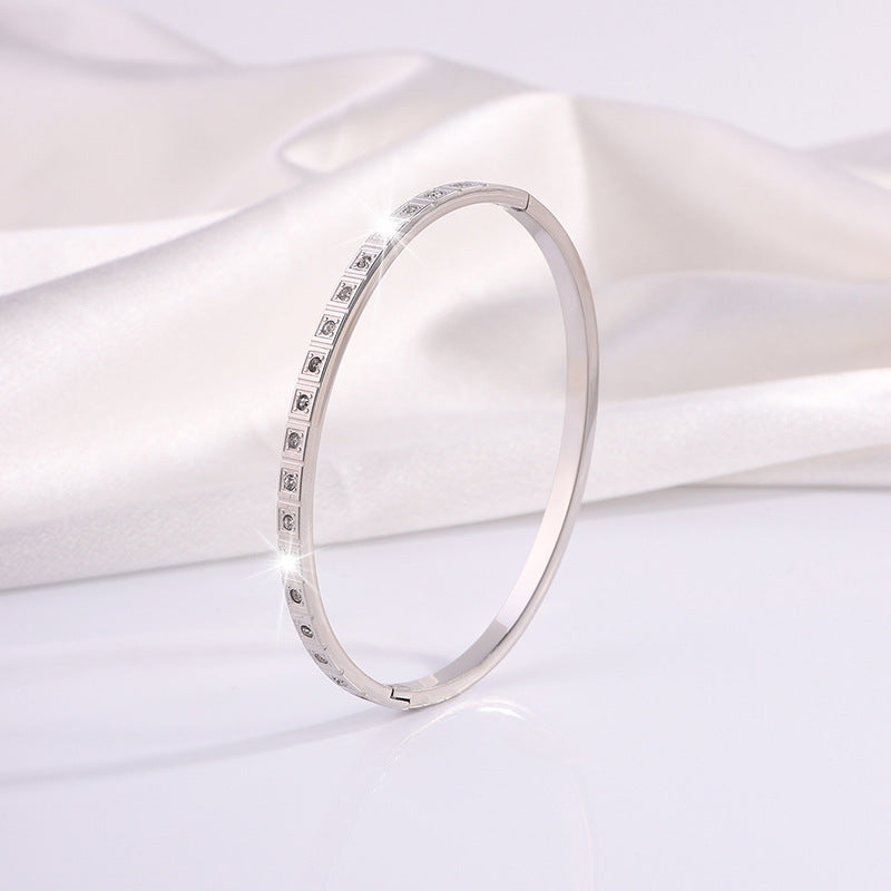 Silver diamond bangle bracelet viewed from side with stone row