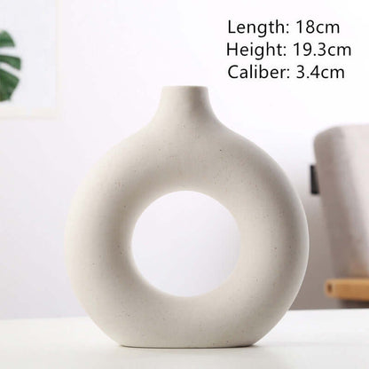 Off-white ceramic vase with circular cutout and short neck opening