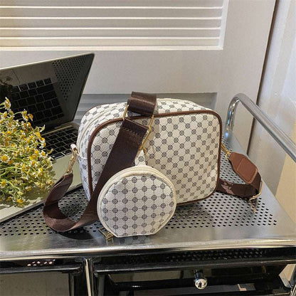 Cream patterned shell crossbody bag with dark strap and round front pouch