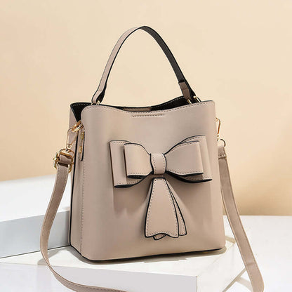 Khaki/beige bow bucket crossbody bag with bow applique and adjustable shoulder strap