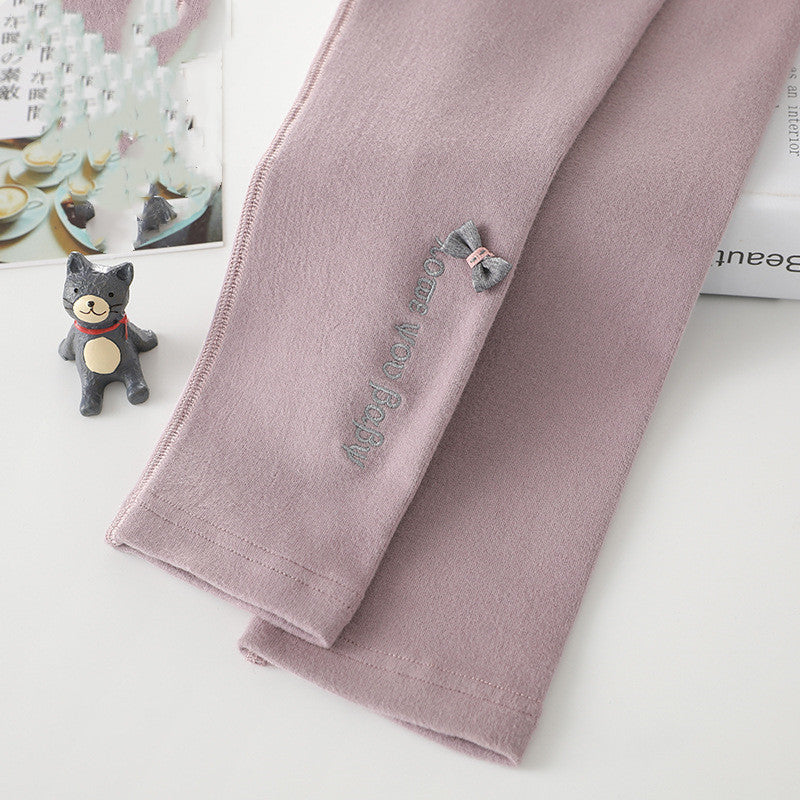 Light pink cotton leggings with bow detail and printed text along the leg