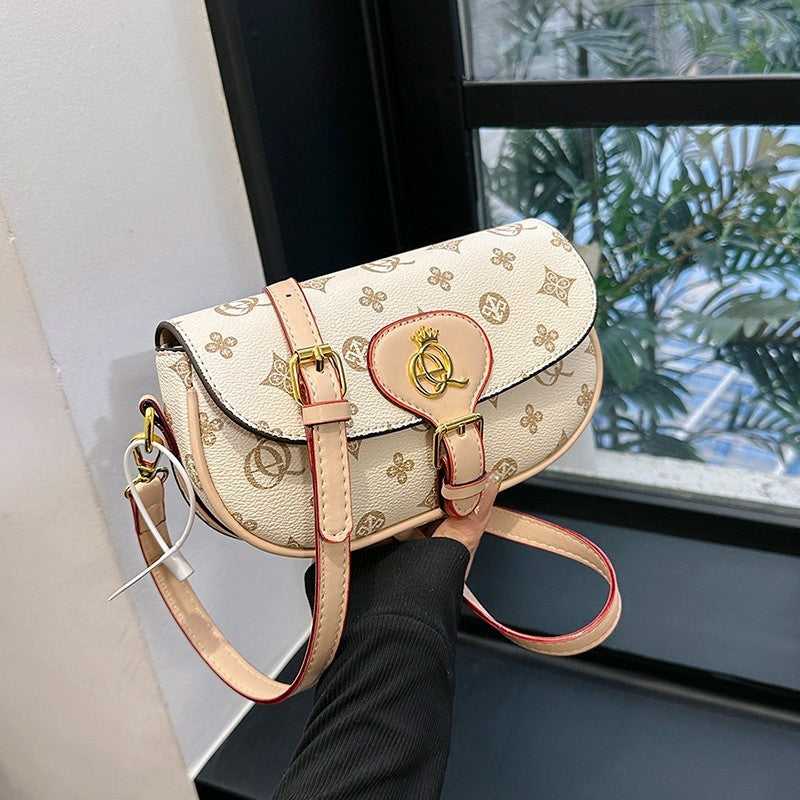 Printed saddle crossbody bag with flap, light beige logo pattern, pink strap, gold clasp