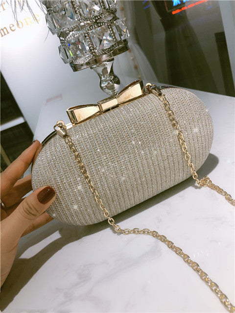 Beige-gold beaded clutch bag with gold-tone clasp bar and chain strap