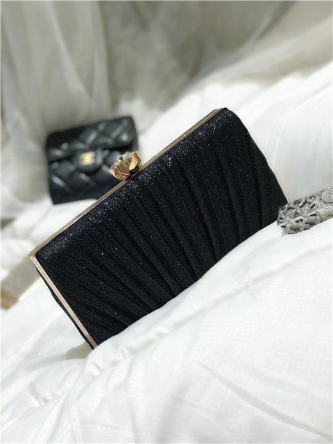 Black glitter clutch bag with gold-tone frame and rhinestone clasp