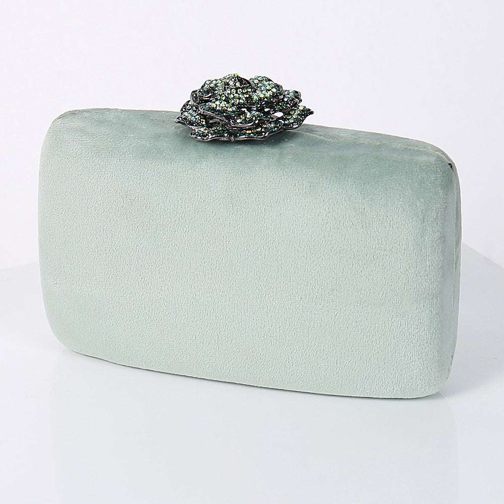 Mint flannel party bag with ornate jeweled floral clasp on top.
