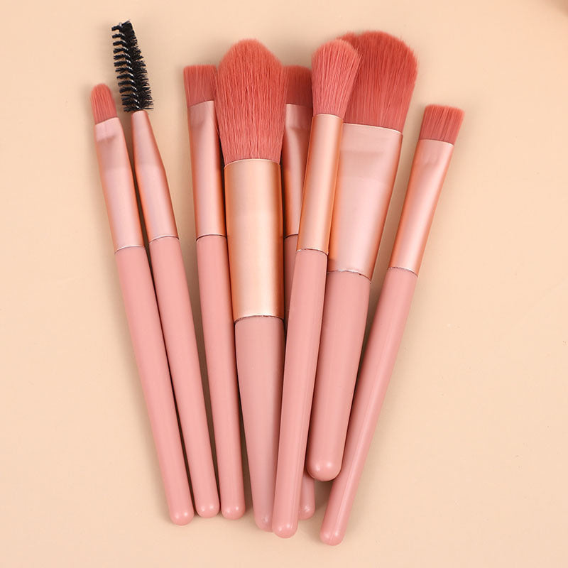 Mini makeup brush set with pink handles and rounded blush brush heads plus spoolies