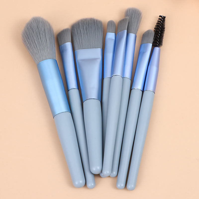 Mini makeup brush set with light blue handles and gray oval powder brush heads