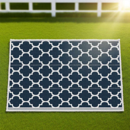 Reversible outdoor rug close-up with navy-and-white quatrefoil pattern and border