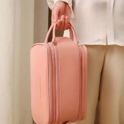 Pink cosmetic bag with two long zipper compartments and rounded handle straps
