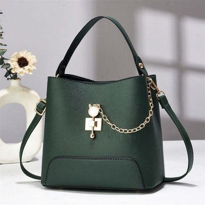 Dark green PU leather bucket bag with top handle, shoulder strap, and gold chain charm