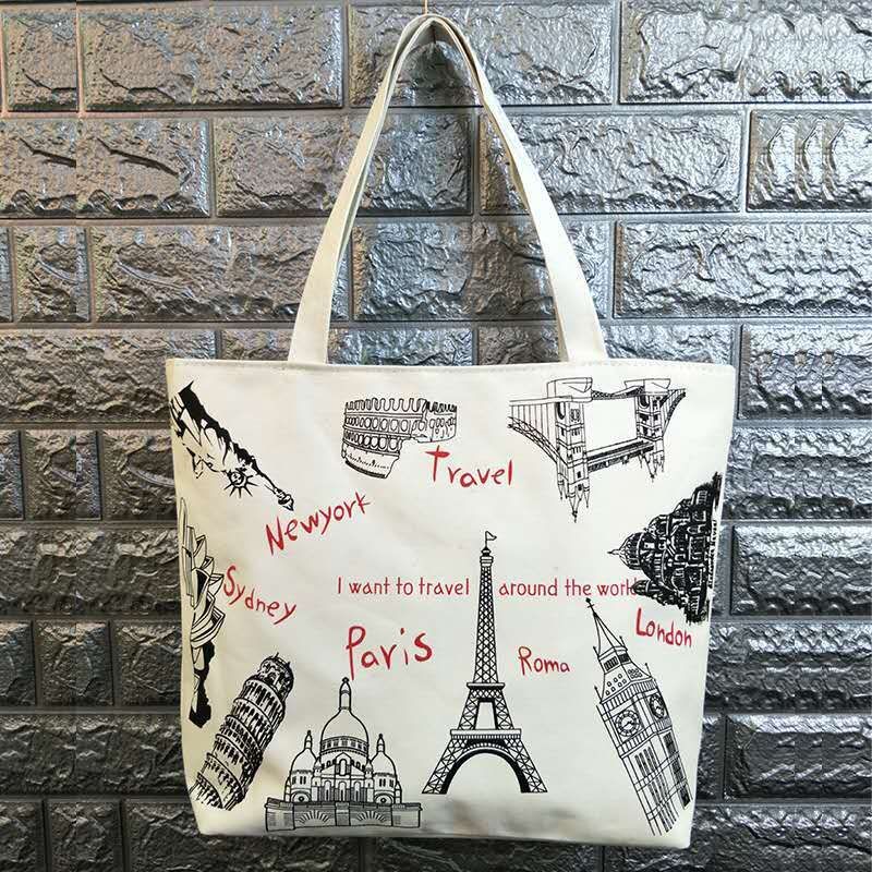 White canvas tote bag with black landmark icons and red city names, top handles