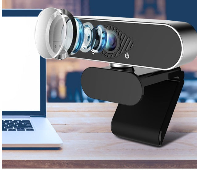 Webcam on a stand with a blurred laptop in the background