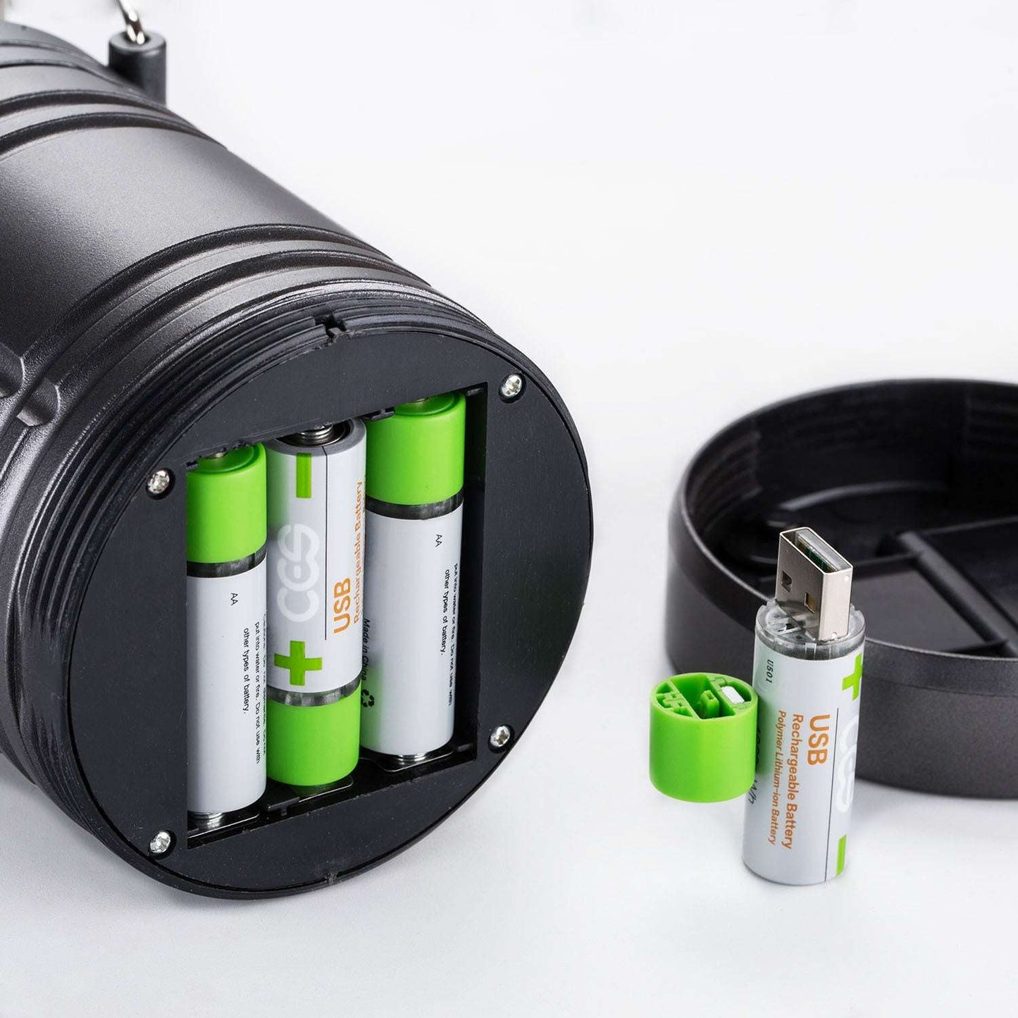 Black battery charger with green and white batteries on a white background