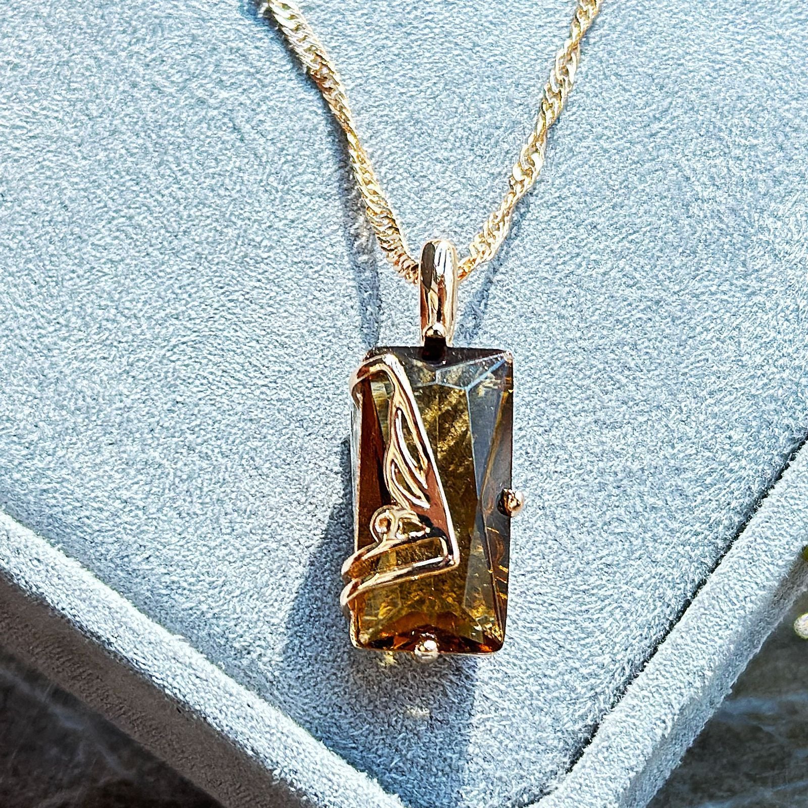Gold-tone necklace pendant with rectangular smoky gemstone on chain