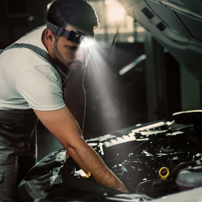 Black LED headlamp on elastic strap worn on a person for hands-free lighting