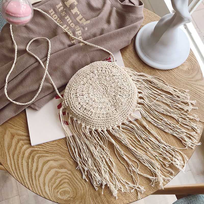 Light cream round crochet crossbody bag with long fringe tassels and cord strap