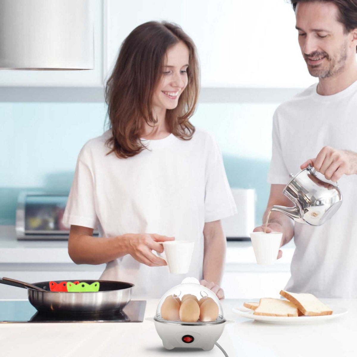 White electric egg cooker with clear lid, holding eggs during meal prep