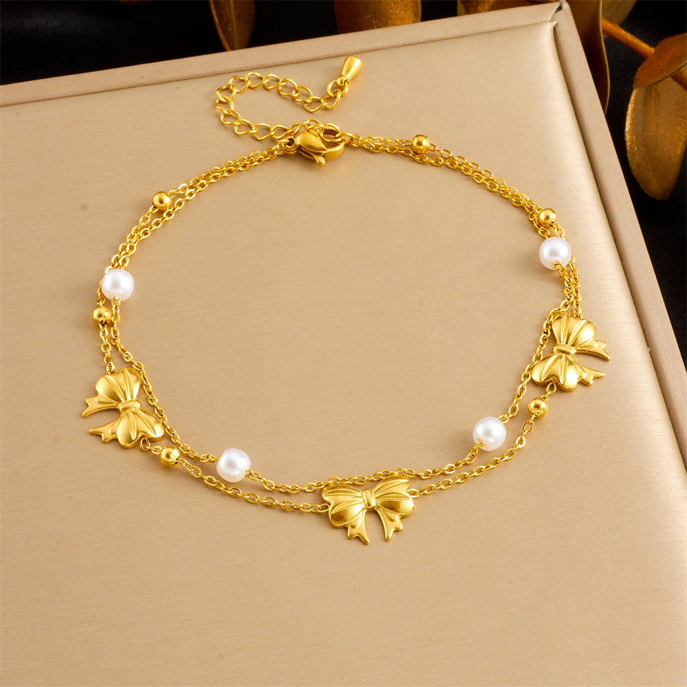 Gold-tone charm anklet with starfish and seashell charms, plus pearl beads