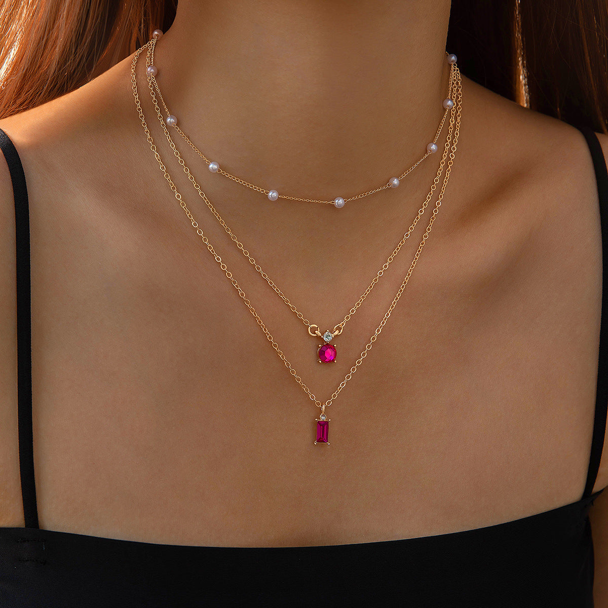 Multilayer pearl necklace with gold chain, pearl choker, and pink round plus pink bar pendants
