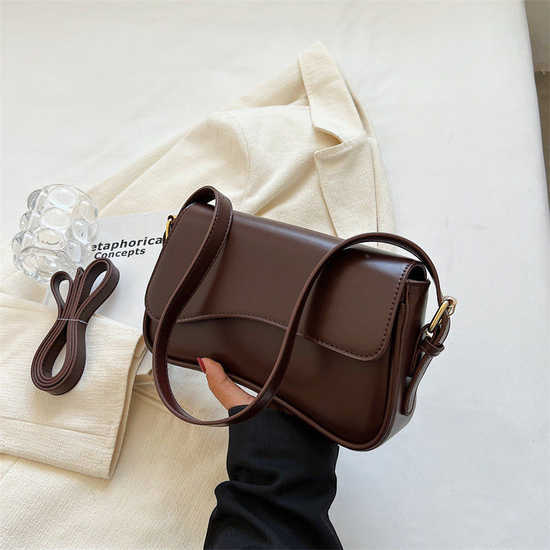 Brown flap shoulder bag with magnetic buckle, side profile and adjustable crossbody strap