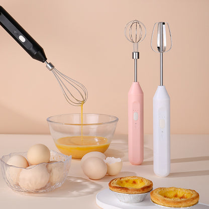 Three electric beaters on a table with eggs and pastries, against a beige background