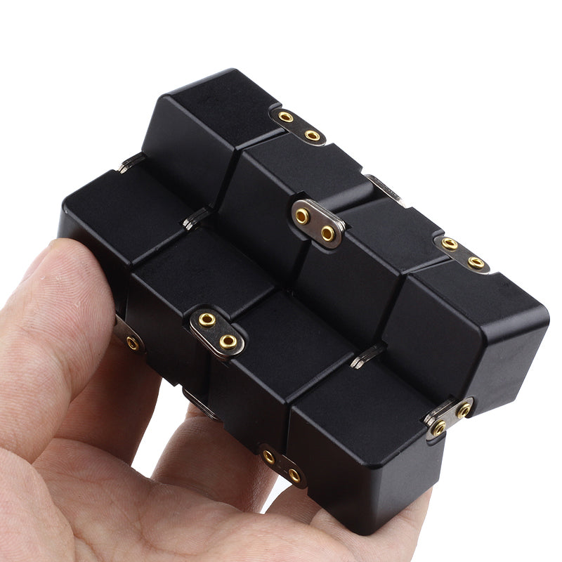 Black puzzle toy held in a hand with 