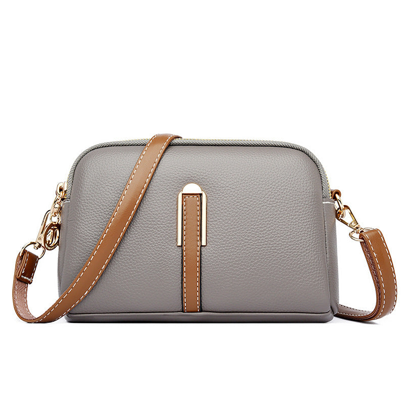 Gray textured shoulder bag with zip top and tan front strap detail