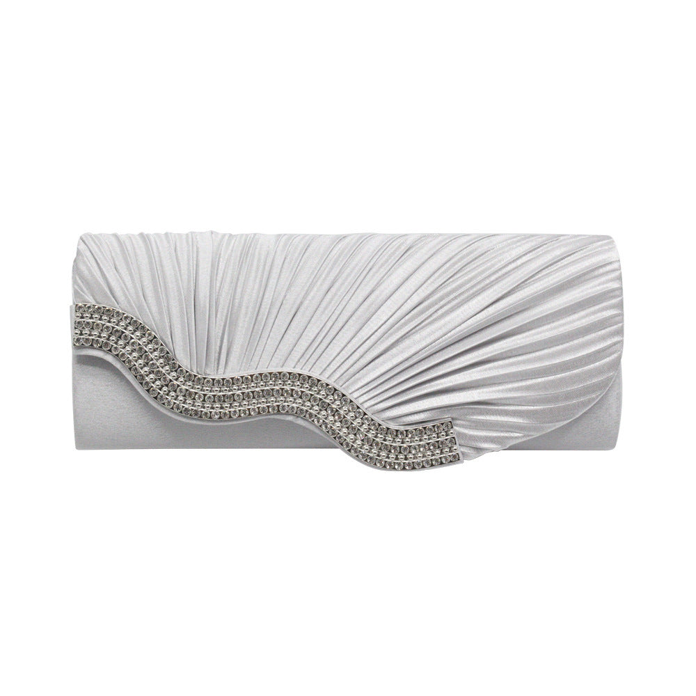 White pleated clutch with silver rhinestone curved band on the front flap