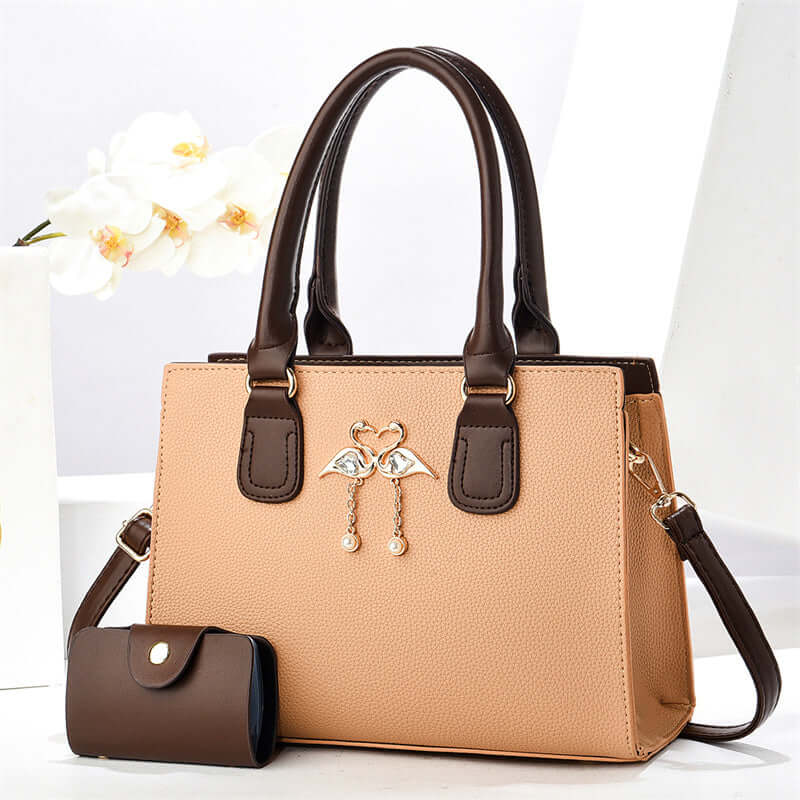 Beige large crossbody tote bag with brown handles, front heart charm, and side pouch