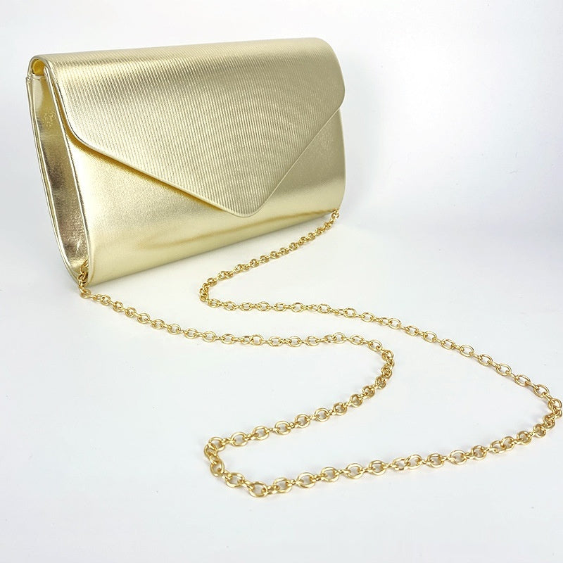 Gold envelope clutch with top flap and chain strap, textured finish
