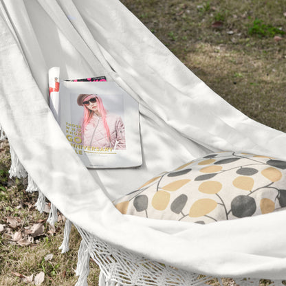White macrame hammock with tassel fringe and woven seat with patterned cushion