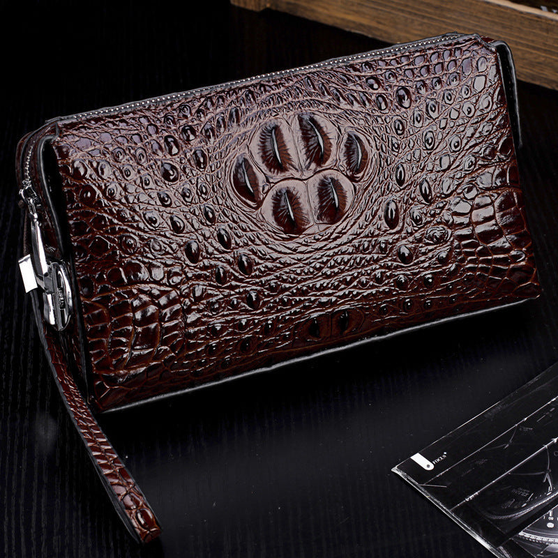 Men's brown crocodile-pattern zip wallet angled view with paw emblem and metal zipper pull